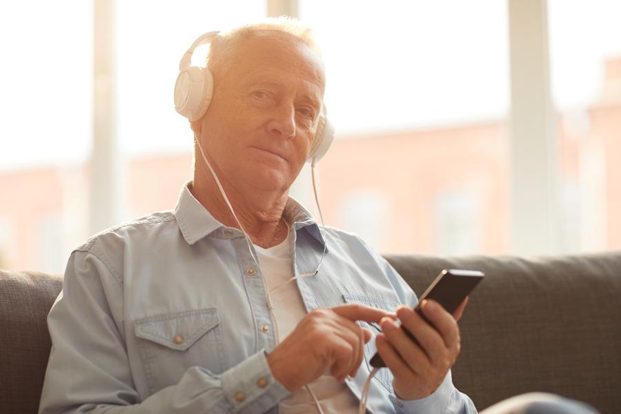 Mann führt einen Online Hörtest mit Kopfhörern durch