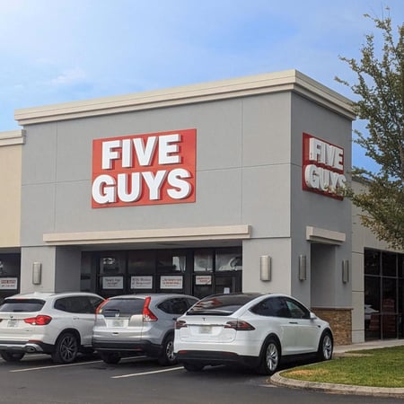 Exterior photograph of the entrance to the Five Guys restaurant at 501 North Orlando Avenue in Winter Park, Florida.