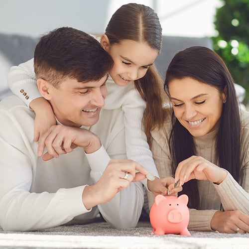 Family putting change in piggy bank