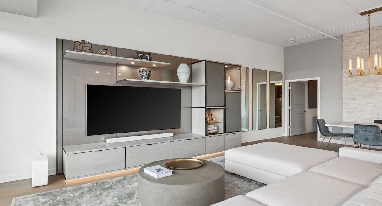 Modern built-in entertainment center with light wood cabinets, shelving, and media storage solutions for living room organization