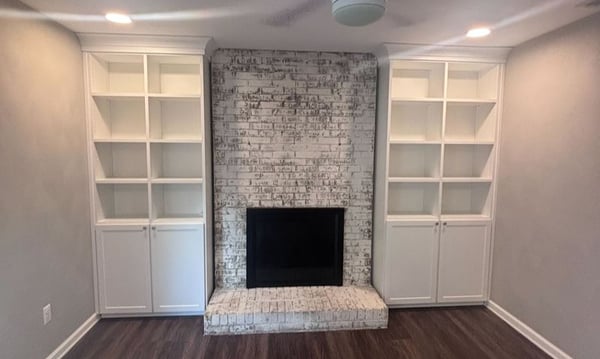 Virginia Beach - Custom closets - Built-in shelving and cabinetry framing a whitewashed brick fireplace.