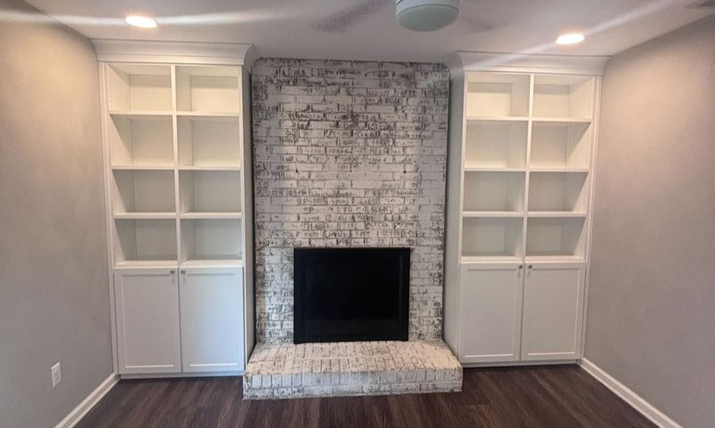 Virginia Beach - Custom closets - Built-in shelving and cabinetry framing a whitewashed brick fireplace.
