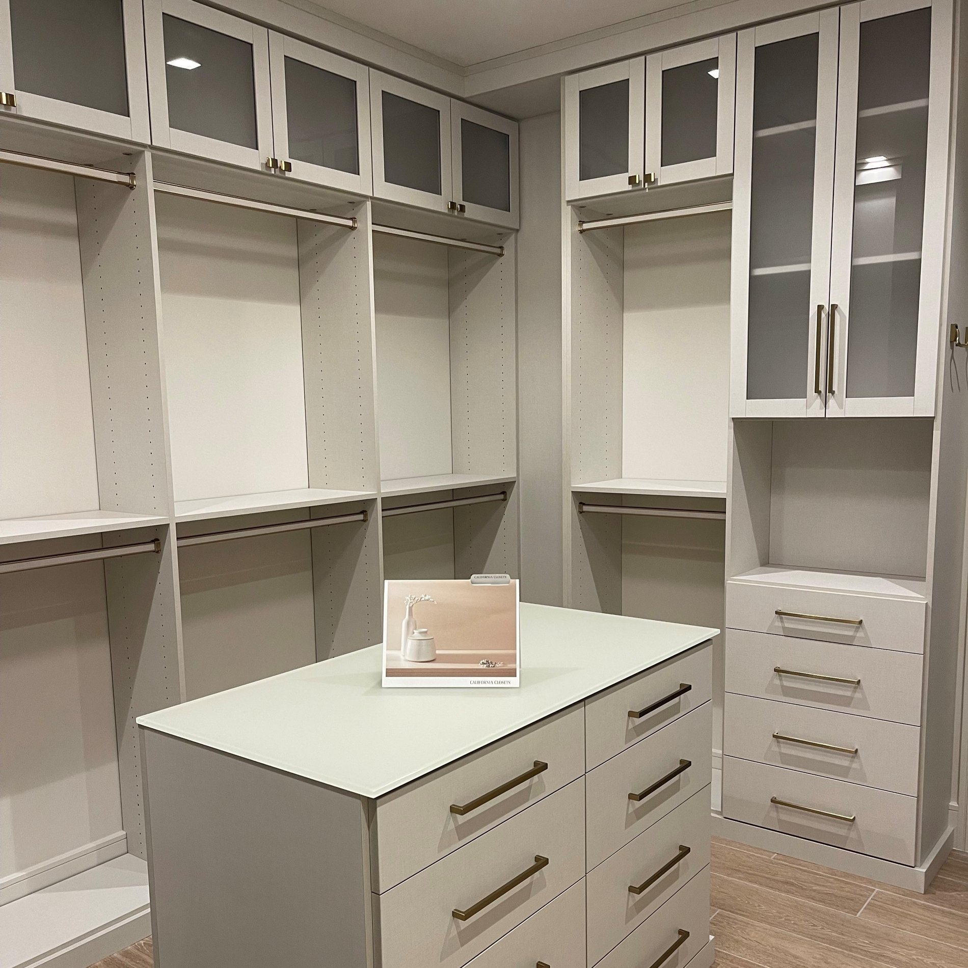 Custom linen-finish bedroom closet with gold hardware, linen pole inserts, shaker doors with frosted glass, and matte glass countertop.