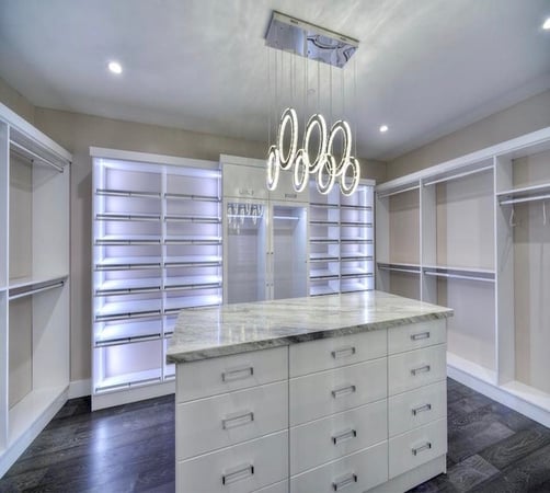 Custom walk in closet design with closet systems, island storage, and closet organization