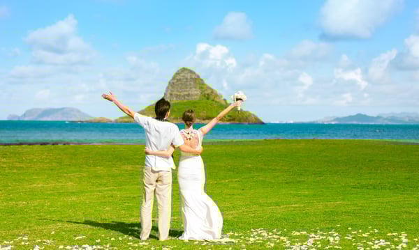 海がみえる芝生でポーズをきめる新郎新婦の後ろ姿