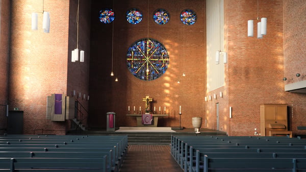 Innenansicht von der Martin-Luther Kirche mit Blick auf den Altar. Über dem Altar ist ein großes rundes Buntglasfenster.