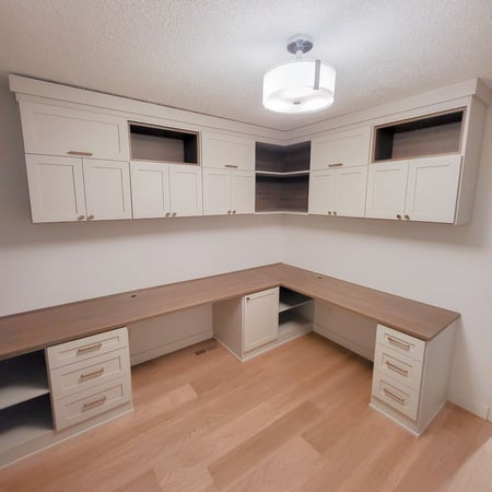 Home office with two work stations, upper cabinetry, pull out shelves, and drawers. Contrasting finishes create a unique look.