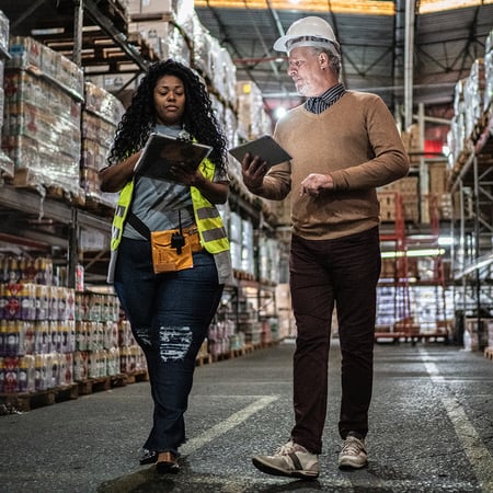 Man and woman walking together in a warehouse.