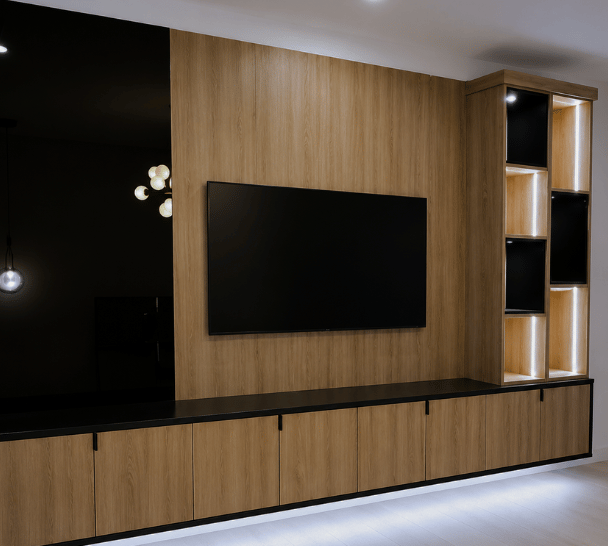 Custom modern media center and TV wall storage with warm oak wood finishes, matte black panels, floating cabinets, integrated LED lighting, built-in display shelving, and mounted TV storage by California Closets in Boca Raton, Florida. In South Palm Beach, Florida.