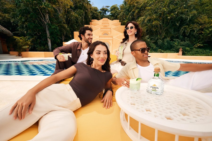 a group of people around a bottle of patron silver