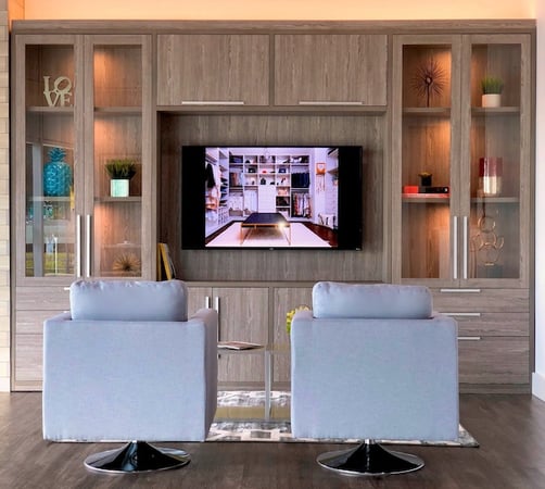 Custom brown Entertainment center with a TV, has drawers, doors, and shelves