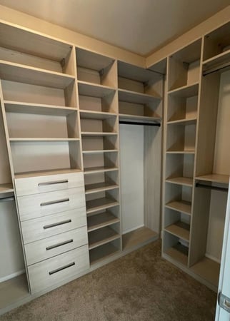 A custom walk-in closet featuring both shelves and drawers.