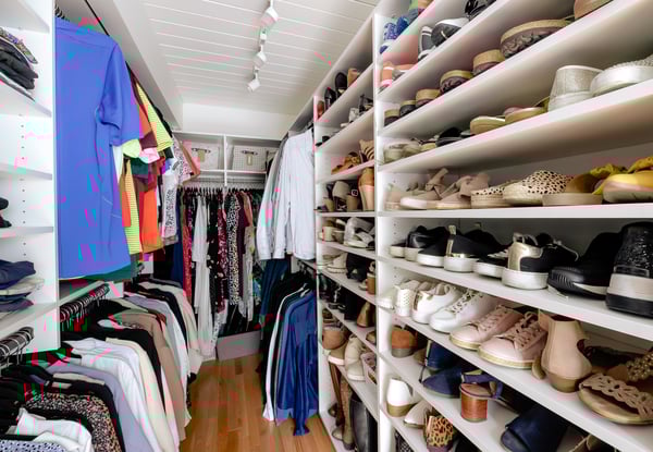 View of walk in closet showing shoe shelves and hanging space