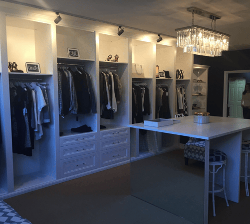 Walk-in closet with hanging space, shelving, drawers, and a counter with mirrored siding.