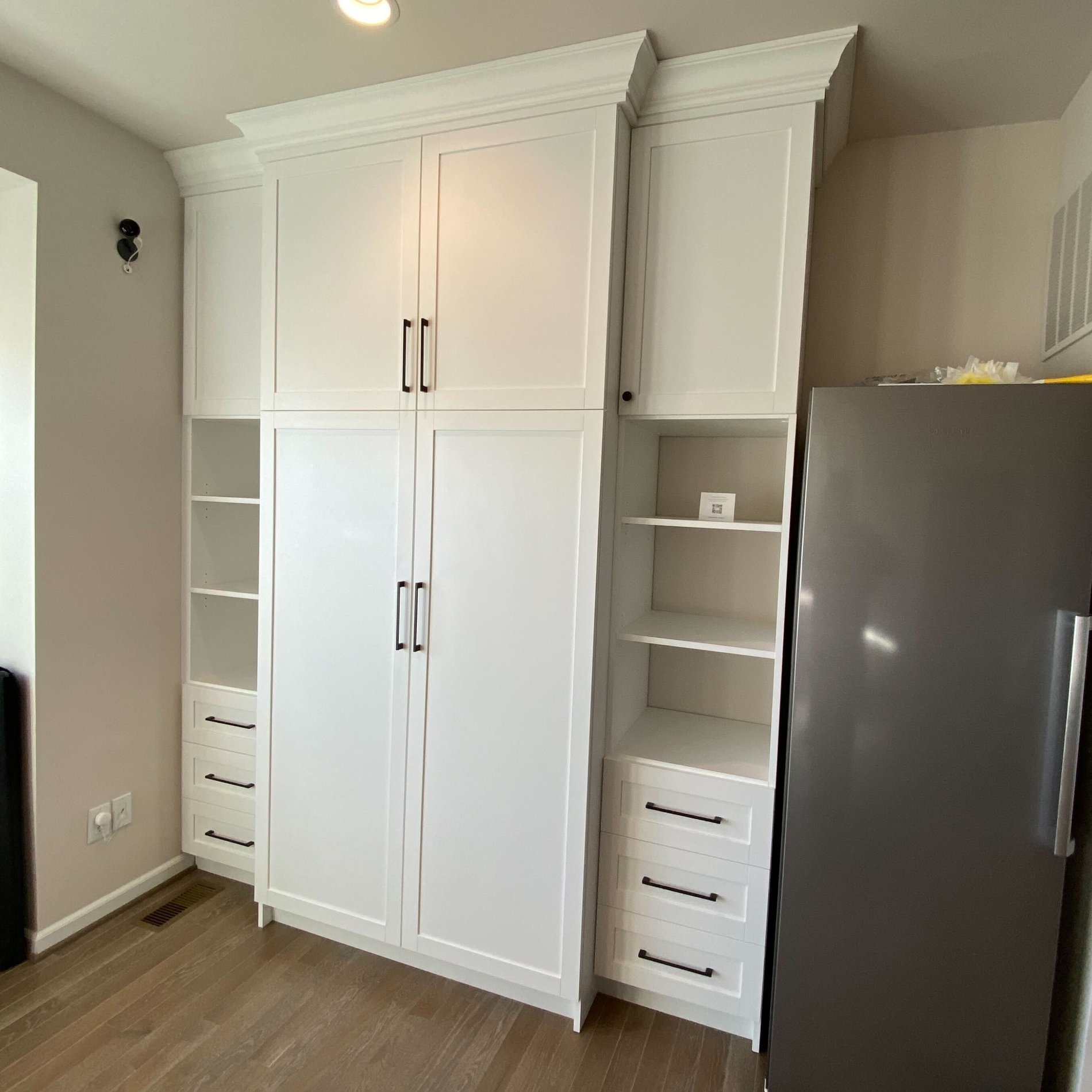 a wall unit built from floor to ceiling with doors, drawers, and shelves