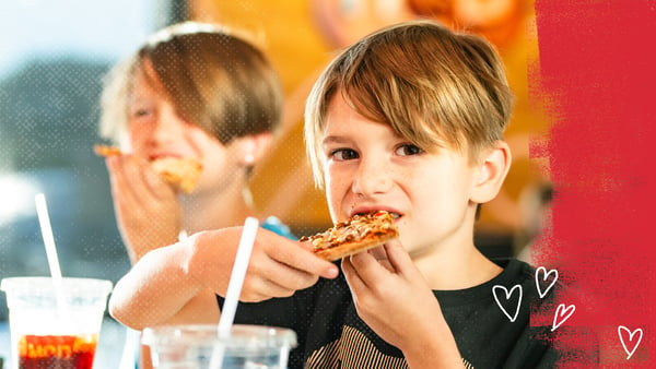 A young MOD fan takes a bite from his  kid's cheese pizza