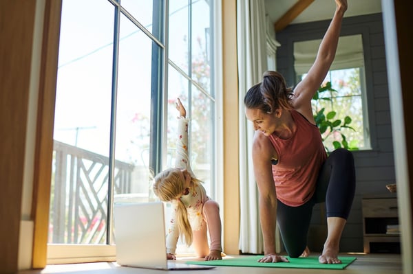 Madre e hija haciendo yoga en casa