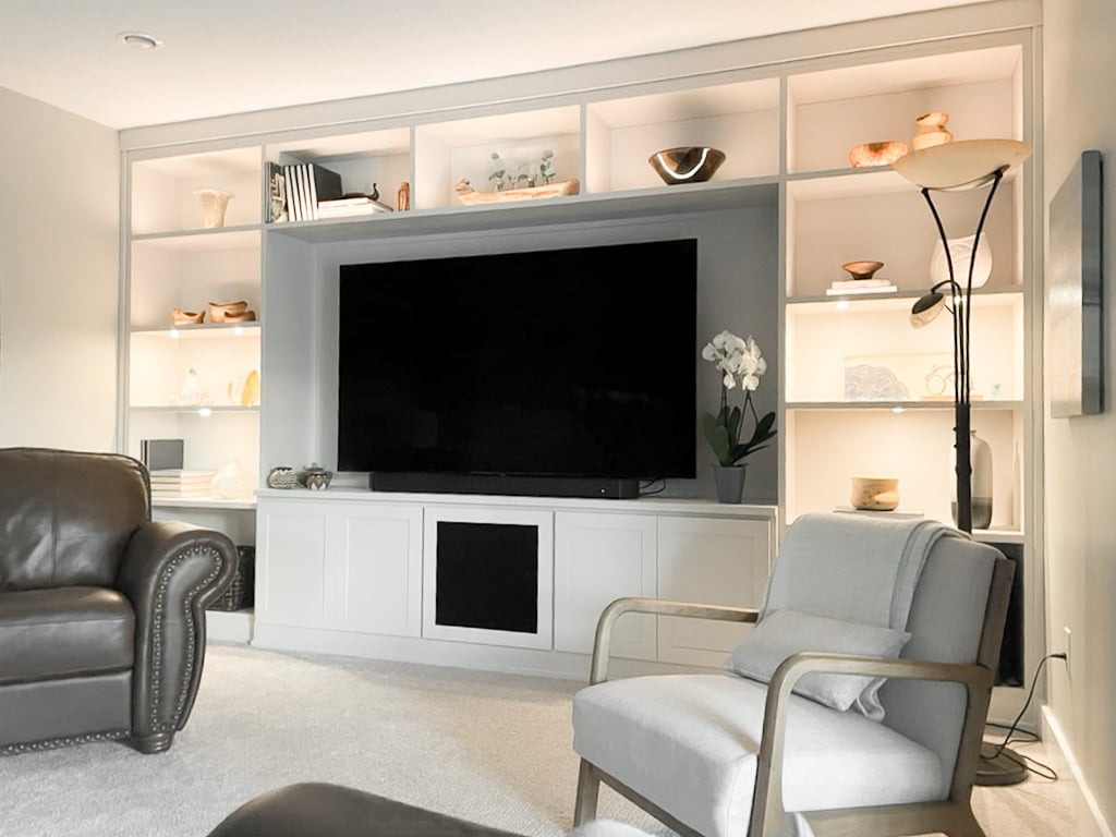 White media centre with open shelving, closed storage, and lighting.