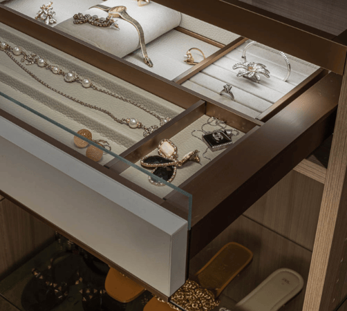 Img 5 California Closets Westchester County New York Two Toned White and Beige Large Walk-in Luxury Closet with Glass Shelving, Glass Doors, Lighting, and a Custom Center Island with Custom Jewelry Drawers