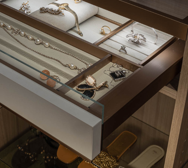 Img 5 California Closets Westchester County New York Two Toned White and Beige Large Walk-in Luxury Closet with Glass Shelving, Glass Doors, Lighting, and a Custom Center Island with Custom Jewelry Drawers