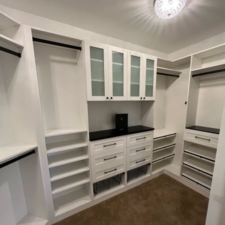 Master Walk In Closet with hanging space and drawers for organizing coats and accessories