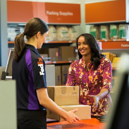 Customer dropping off AT&T equipment to FedEx Office team member at counter