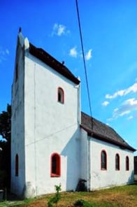 Außenansicht der weißen Kirche vor blauem Himmel.