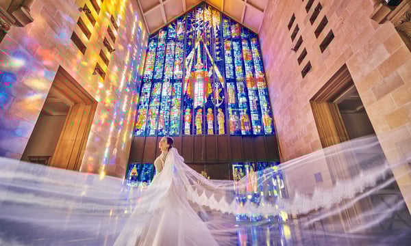 ステンドグラスの前に立つ花嫁