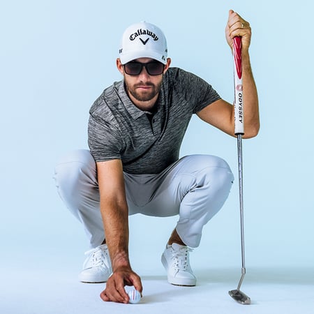 golfer setting down a golf ball while wearing oakley eyewear