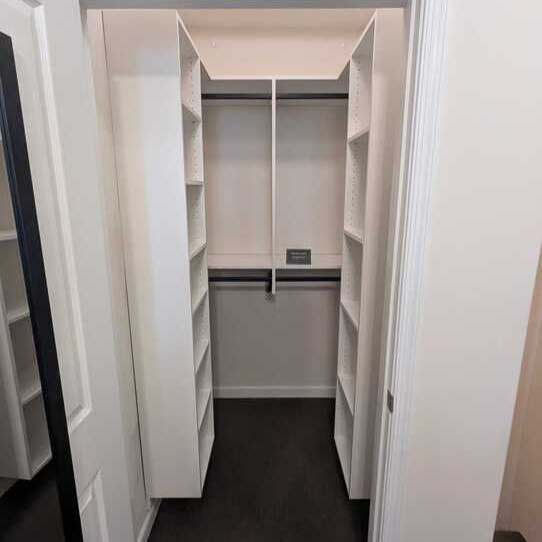 Virginia Beach - Custom closets - Narrow walk-in closet with shelving and hanging rods on both sides.