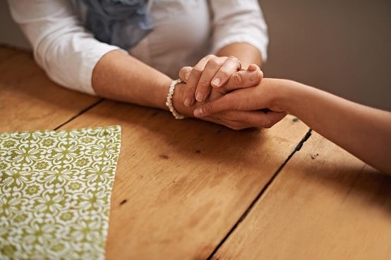Hands held at a bereavement support group in Waltham Abbey