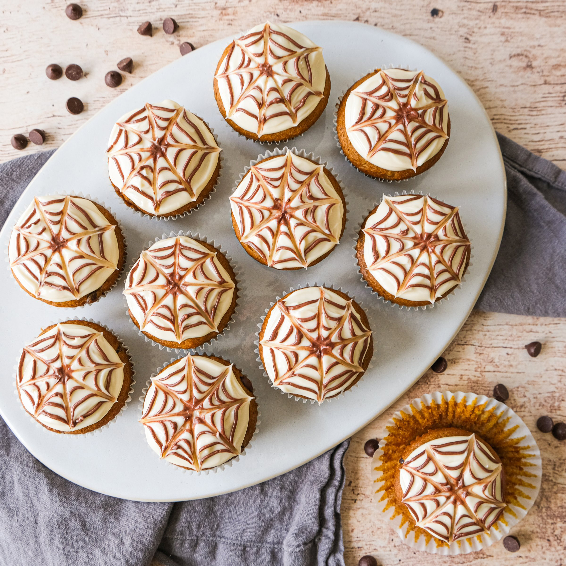 pumpkin chocolate chip spider web cupcakes with cream cheese frosting
