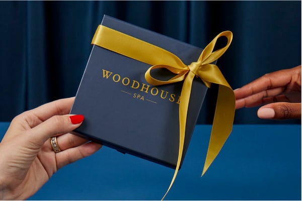 Someone gifting their friend or family member a Woodhouse Spa gift card.