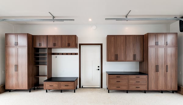 Upgraded garage storage designed in a mid-century finish with contrasting black countertop and bench top. Floor to ceiling storage, open shelving, and drawers provide enough storage for everyday essentials.