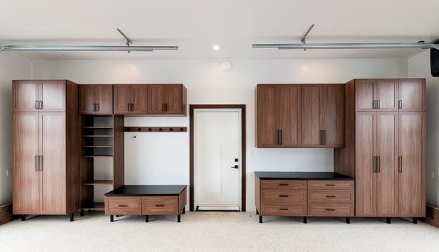 Upgraded garage storage designed in a mid-century finish with contrasting black countertop and bench top. Floor to ceiling storage, open shelving, and drawers provide enough storage for everyday essentials.