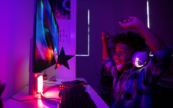 Teen gaming on computer, while using fiber internet