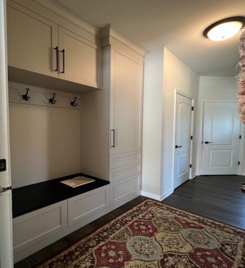 Custom family mudroom with white doors and shelves plus bench seating.