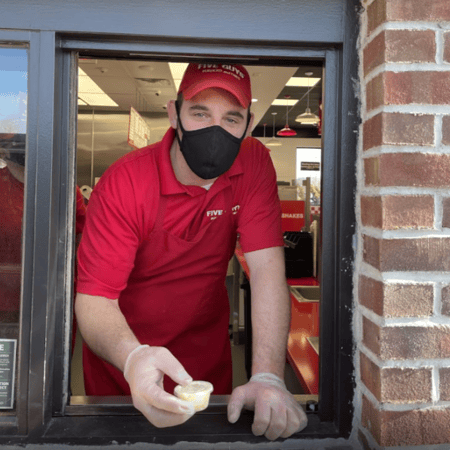 A Five Guys employee helps a customer at one of our mobile pickup windows.