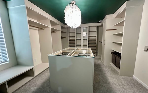 Luxury walk-in closet featuring custom closet organization with built-in shelving, hanging storage, wardrobe cabinets, and a center island with jewelry storage. This custom walk-in closet by California Closets includes closet systems, shoe storage, custom storage solutions, and personalized home organization designed for elevated bedroom storage, South Lyon, Michigan