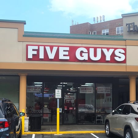 Exterior photograph of the Five Guys restaurant at 25455 Horace Harding Expressway in Little Neck, New York.