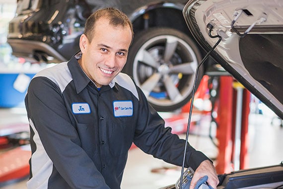 a AAA auto repair mechanic works on a car at an auto repair center