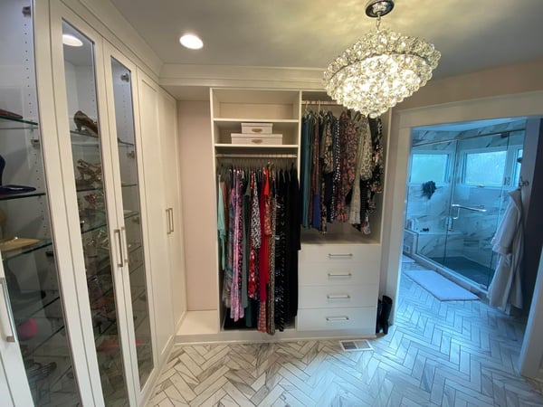 Lovely walk-in with glass shelves behind windowed doors