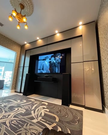 The theater room features a custom Proscenium design with Shadow Black and Metallic Champagne Northern Contour doors, including unique top-hinged, side-mounted doors, blending standard components with a stacked Virtuoso system.