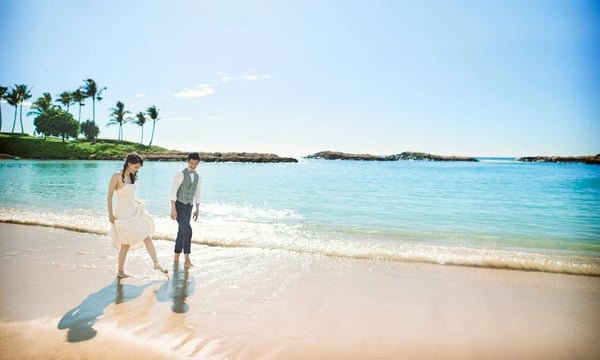 浜辺を歩く新郎新婦