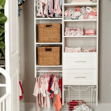 Reach-in nursery closet with organized kids' clothes