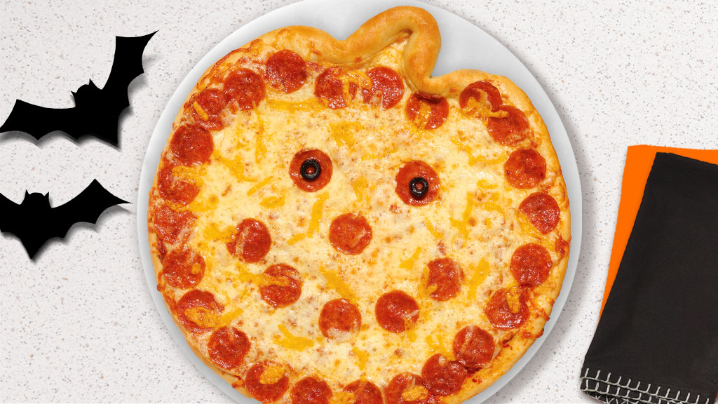 pumpkin-shaped, jack-o-lantern, take and bake pizza with a pepperoni face and black olive eyes