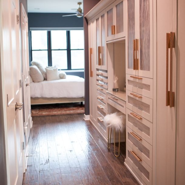 Custom Walk-Through Closet Space with Built-In Vanity Area, Glass Blacking, Decorative Frosted Glass Doors, and Sleek, Gold Hardware in Philadelphia, PA
