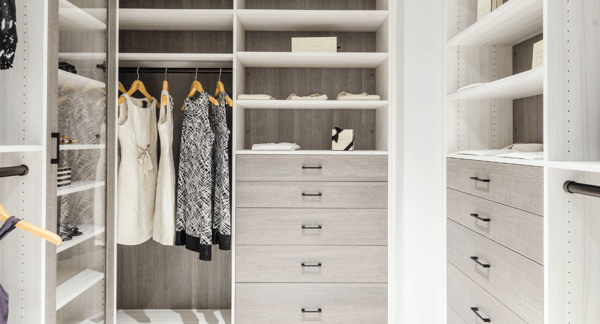 California Closets Hudson Valley NY Walk-in Closet in White and Gray with Hanging Drawers Shelving and Clear Glass Doors to Display Purses