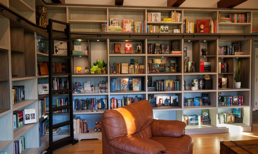 Custom home library with over-door shelving and push-release doors in Souderton, Pennsylvania by California Closets of Philadelphia and Delaware