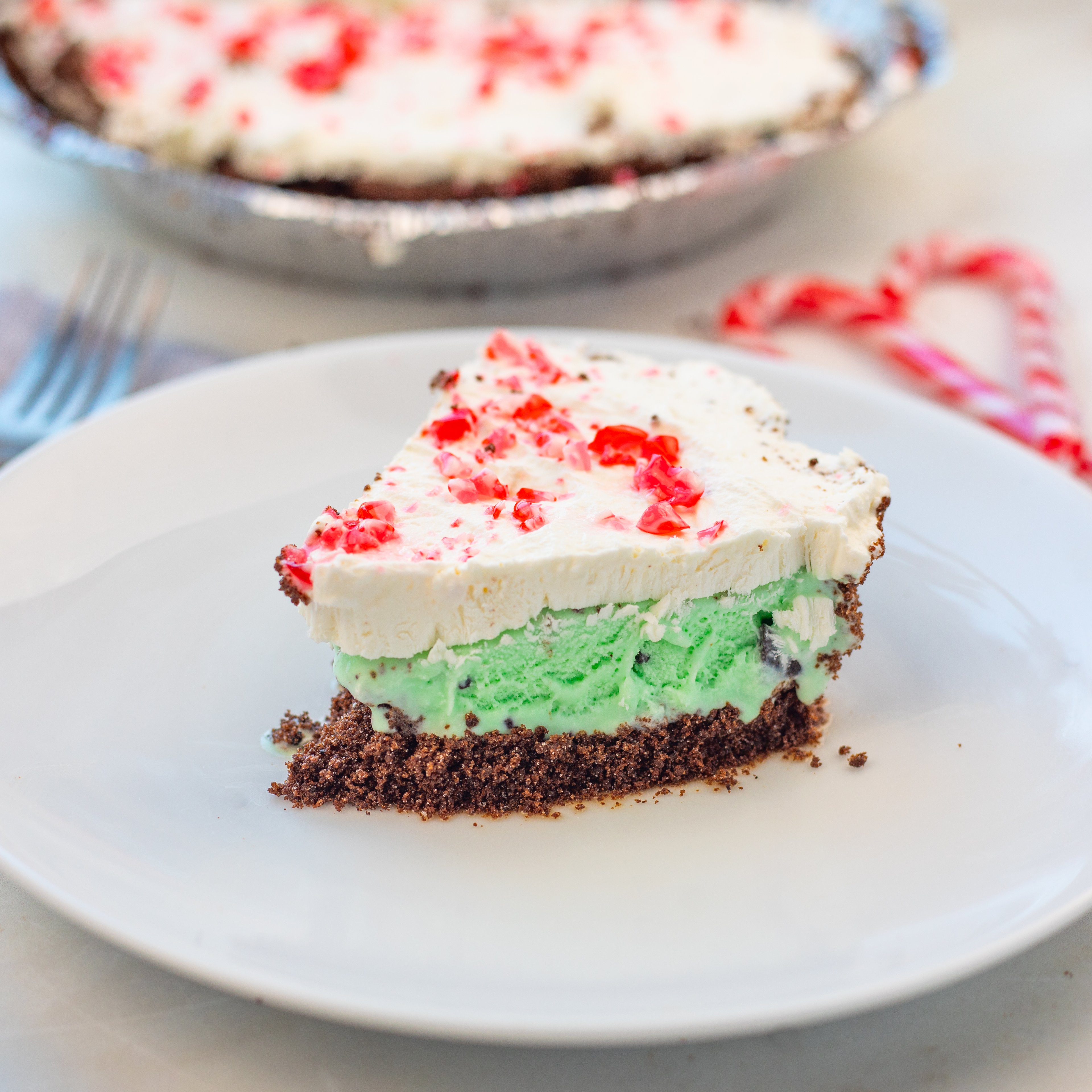 mint chip ice cream pie with chocolate crust and candy cane crumble